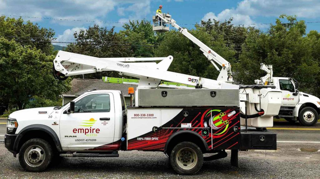Two Empire Access work trucks on a residential street constructing fiber optic internet services