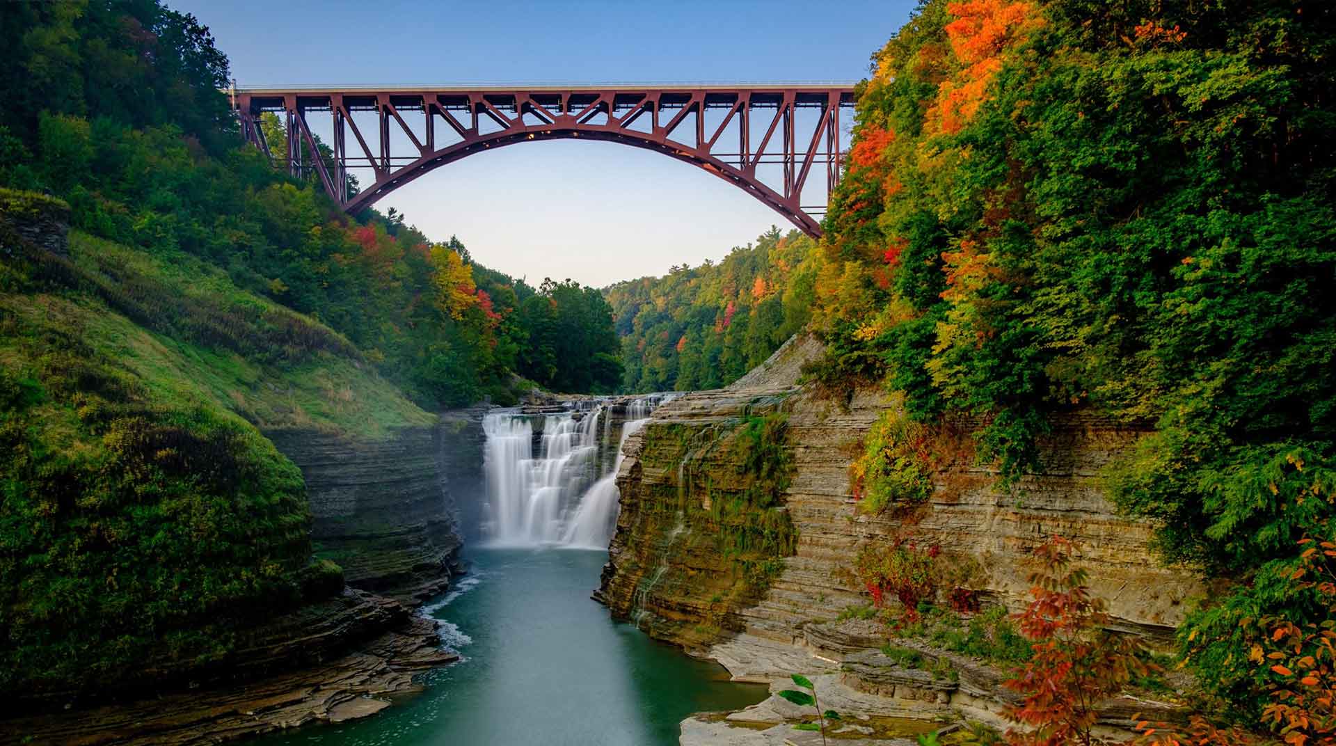 View of the upper waterfalls and railroad bridge at Letchworth State Park during the autumn season