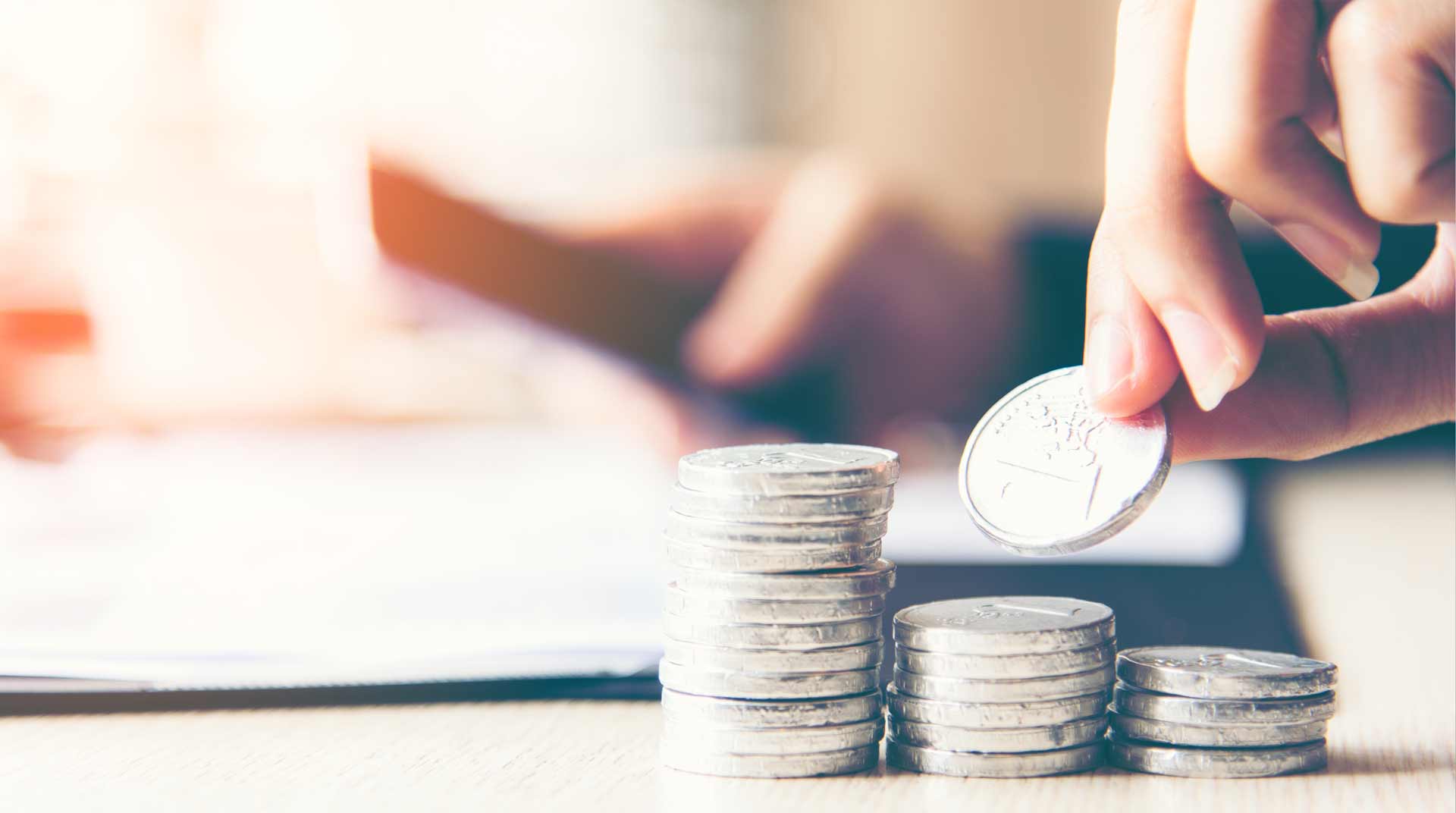 closeup of hands stacking coins on a table