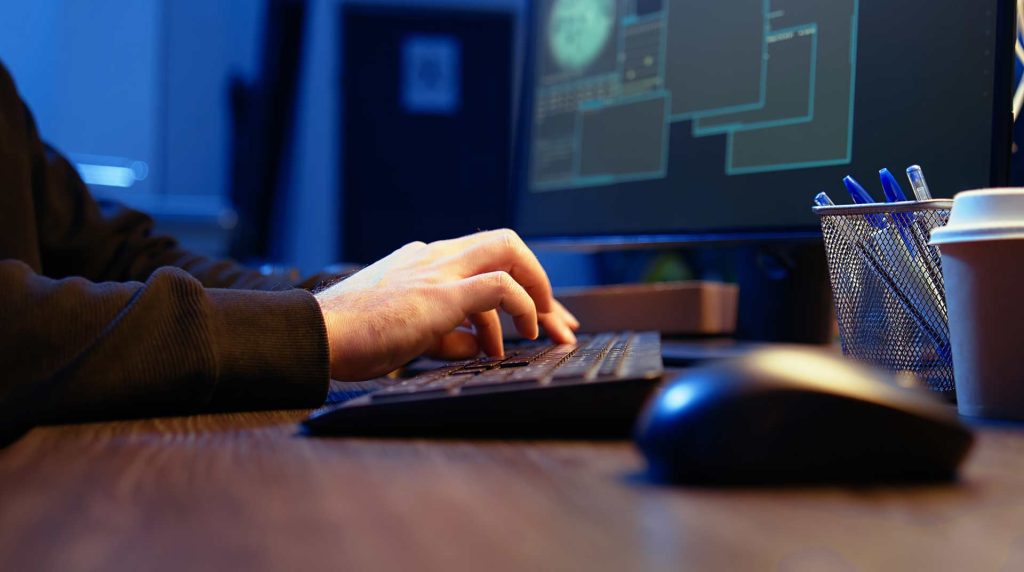 close up of a person's hands typing on a desktop computer's keyboard