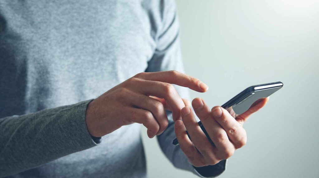 man holding a phone and typing