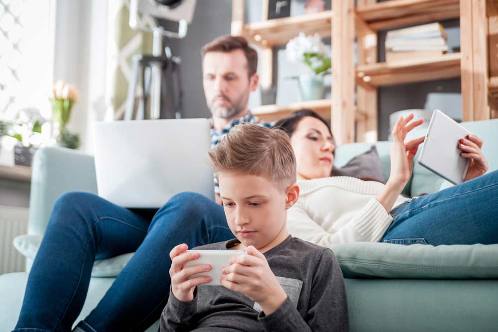 Father and two children using their laptop and phones to connect to the internet