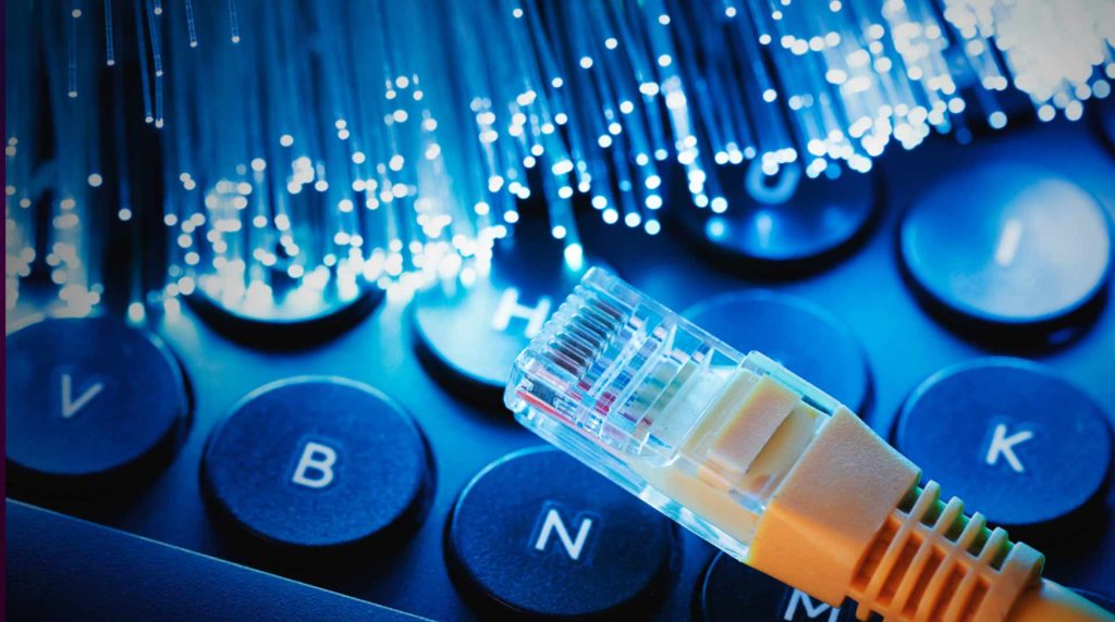 close up of a keyboard, ethernet, and blue fiber