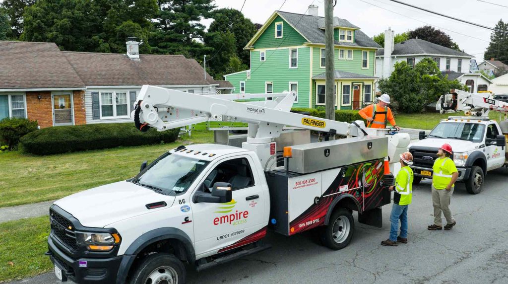 Three Empire Access employees in a neighborhood preparing to install fiber internet