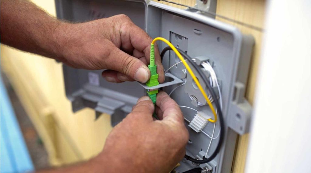 Hands of a man installing fiber at someone's home