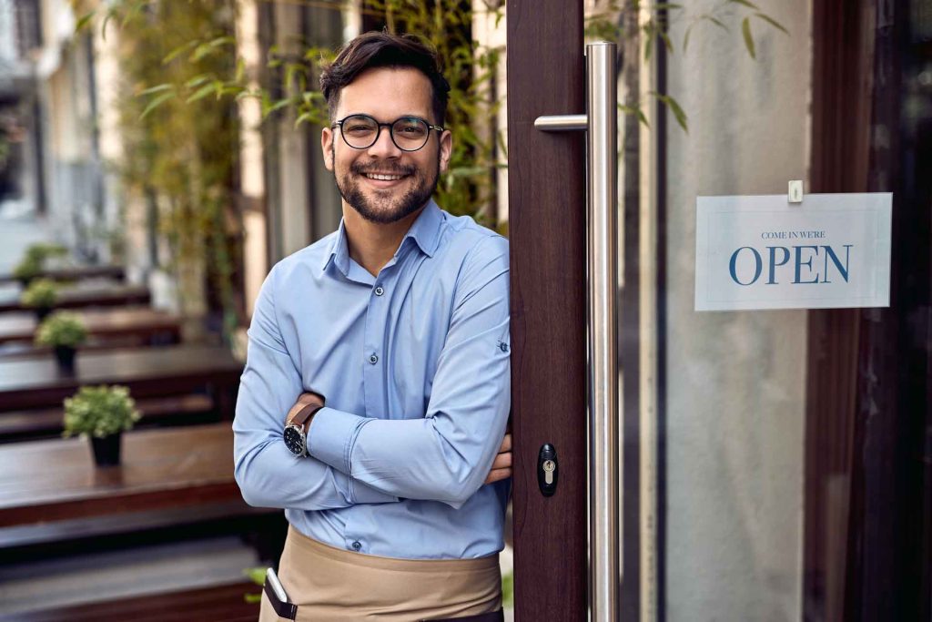 Restaurant owner standing outside by his front door