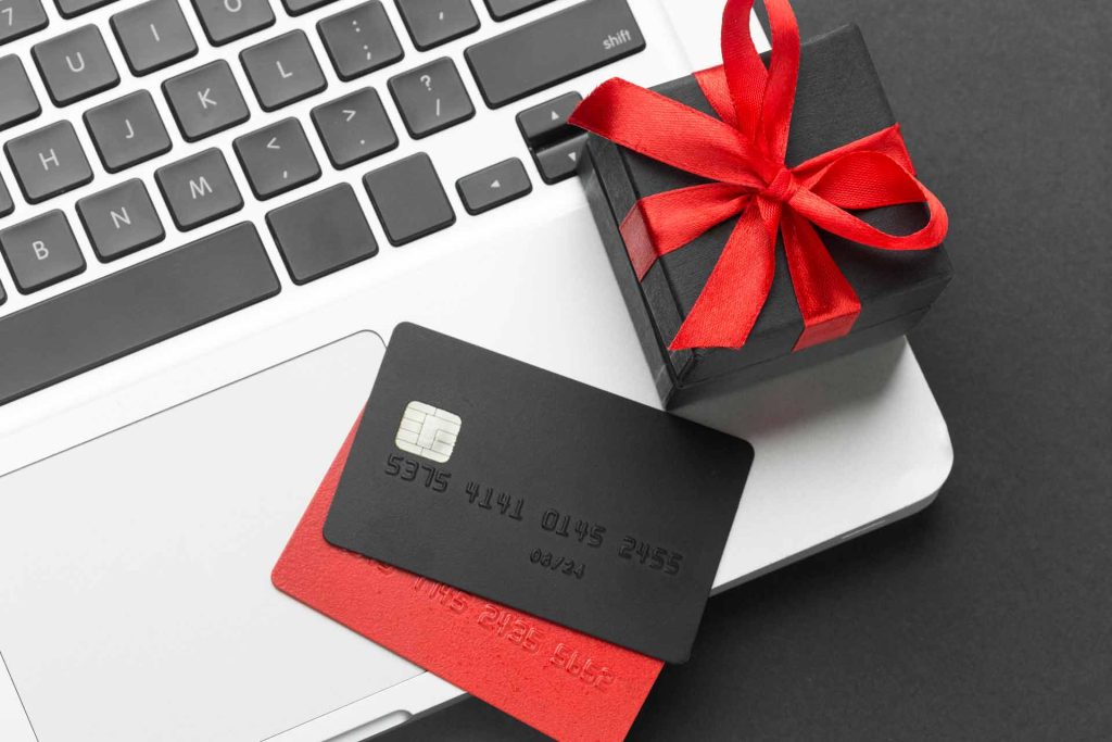 closeup image of a laptop with a gift and gift card depicting Safely Use Your Gift Card Online