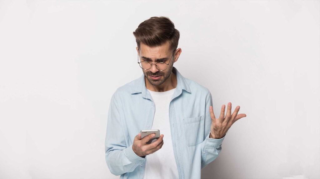 a man holding his phone and showing frustration - ready to break up with your slow internet connection